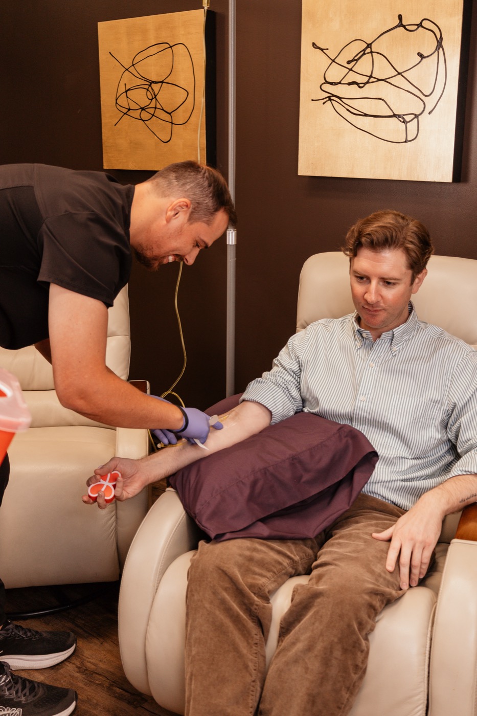 Dr. Kasey Nichols starting an IV for a patient in the lounge chair